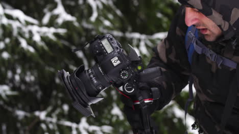 Fotógrafo-En-Bosque-Nevado,-Cierre-Mientras-Toma-Fotos