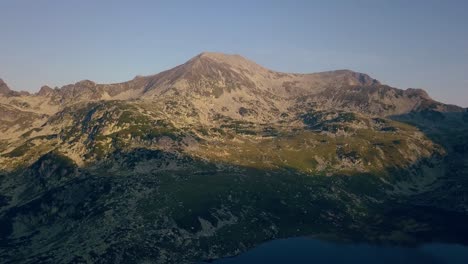 Wide-aerial-drone-slowly-capturing-sun-light-hitting-a-mountain-range