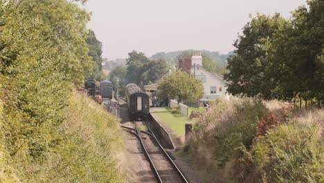 Vintage-Zug-Verlässt-Einen-Malerischen-Bahnhof-Auf-Dem-Land-In-England,-Sommertag
