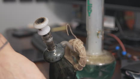 Flames-and-embers-shoot-through-the-stem-of-a-bong-as-a-bowl-of-marijuana-is-smoked