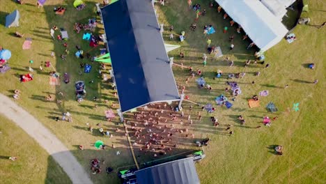 festival-with-dancing-people-in-front-of-a-stage-in-the-swiss-Jura-mountains-with-the-drone-from-the-air-filmed
