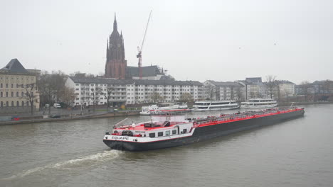 Big-red-freight-carrier-or-cargo-ship-sailing-past-Frankfurt