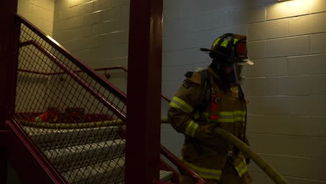 Firefighter-pulls-fire-hose-during-a-firefighting-emergency-training-exercise