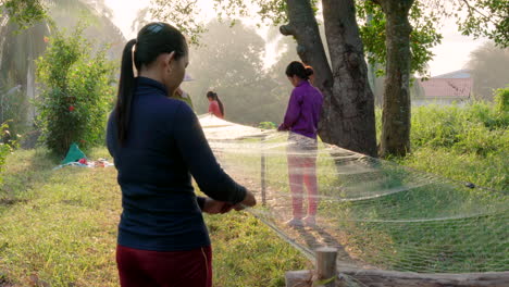Women-making-fishing-nets-under-trees-in-Cambodia