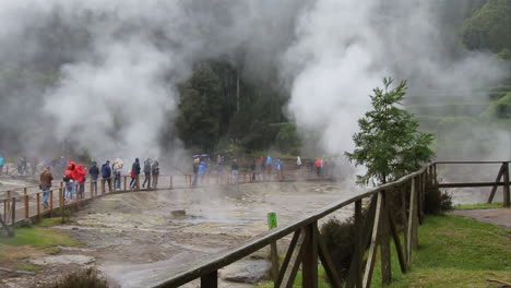 Tourists-walk-amongst-geysers,-hot-springs-and-fumaroles-in-the-village-of-Furnas-and-around-the-Volcanic-lake