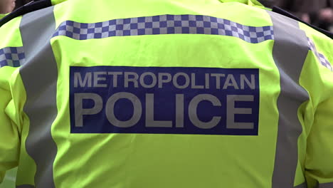 Slow-motion-of-a-officer-in-a-yellow-high-visibility-Metropolitan-Police-jacket