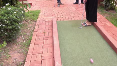 Person-Setting-Up-the-Ball-and-Teeing-Off-at-the-Mini-Golf