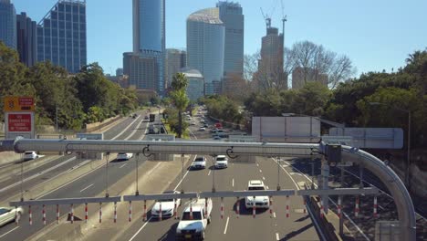 Footage-of-a-busy-Sydney-city-highway-from-a-bridge-with-office-building-on-a-clear-sunny-day,-NSW-Australia