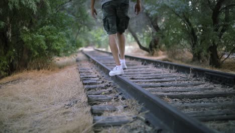 Shot-of-someone-walking-on-abandoned-Train-Tracks-towards-the-camera
