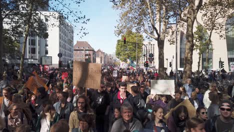Eine-Freundliche-Schar-Von-Demonstranten-Jeden-Alters-Marschiert-Mit-Plakaten-Und-Transparenten-Durch-Eine-Straße-In-Köln,-Um-Politische-Maßnahmen-Gegen-Den-Klimawandel-Zu-Fordern
