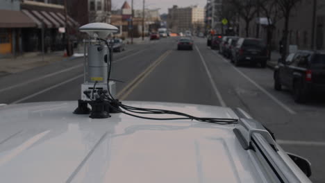 Car-mounted-view-of-autonomous-LIDAR-street-mapping-device-moving-through-city