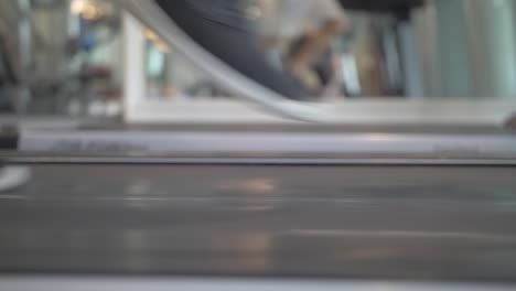 Close-up-shot-of-a-man-with-black-trainers---sneakers-running-on-a-treadmill-in-slow-motion