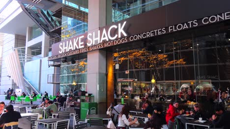Shake-Shack-fast-food-restaurant-in-Tokyo-city-Japan,-4K-panning-left