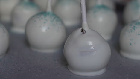 Close-up-shot-of-pastry-edible-glitter-falling-on-white-cake-pops,-slow-motion-120fps