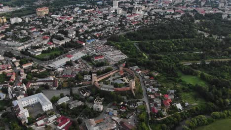 Aerial-View-of-City-With-Medieval-Fort-Surrounded-by-Buildings-and-Woods-in-Eastern-Europe