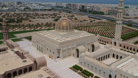 Aerial-drone-view-of-amazing-Sultan-Qaboos-Grand-Mosque-panning-from-left-to-right-while-overlooking-the-city-of-Muscat-in-Muscat-in-Oman