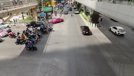 Lapso-De-Tiempo-De-Una-Concurrida-Intersección-En-Bangkok-Durante-Las-Horas-Pico-Con-Autos-Y-Motos-Parando-Y-Conduciendo,-Tailandia