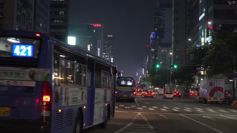 Busy-urban-main-street-of-Gangnam,-buses-and-traffic-at-night,-static,-Seoul-city,-South-Korea