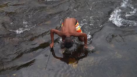 Spear-fishing-in-the-river-by-a-local-Thai-boy,-top-down-view-in-slow-motion