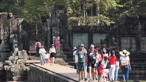 Medium-Shot-of-Tourists-Leaving-a-Temple-on-the-Walkway-at-Angkor-Wat