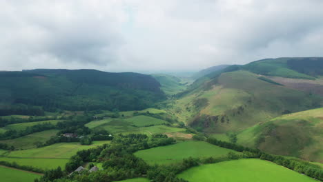 Aerial-panning-shot-showing-the-green-countryside-in-the-English-Lake-District,-bright-but-cloudy-day