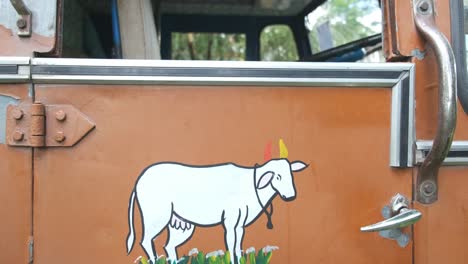 Jib-up-from-painting-of-a-cow-on-door-into-a-typical-Indian-truck-driver's-cabin