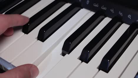 Male-hand-playing-piano-keys