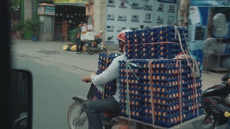 Hombre-Montando-Un-Ciclomotor-Transportando-Una-Gran-Cantidad-De-Cajas-De-Huevos