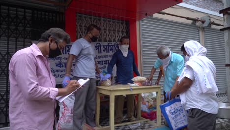People-donating-and-distributing-emergency-food-ration-to-poor-people-in-India-during-Covid-19-coronavirus-lockdown