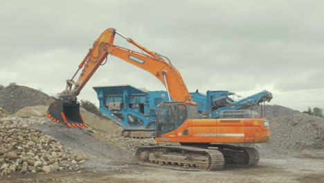 Digger-with-brand-new-large-steel-bucket-pivoting-to-prepare-working-in-quarry