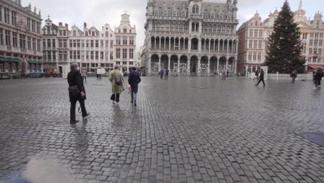 Walking-through-the-gate-of-the-Town-Hall-to-the-Grand-Square-in-Brussels,-Belgium-during-Christmas-period-time