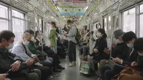 Japanische-Pendler-Tragen-Masken-In-Einem-Fahrenden-Zug-In-Tokio,-Japan-–-Neues-Normales-Gesundheitsprotokoll-–-Statische-Aufnahme,-Zeitlupe