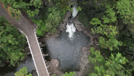 Absteigende-Luftaufnahme-Von-Oben-Nach-Unten-Auf-Einen-Idyllischen-See-Mit-Schwimmenden-Einheimischen,-Umgeben-Vom-Grünen-Dschungel-Hawaiis