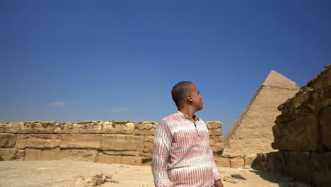 Man-Looking-Around-The-Pyramids-Of-Giza-In-Cairo,-Egypt---tracking-shot
