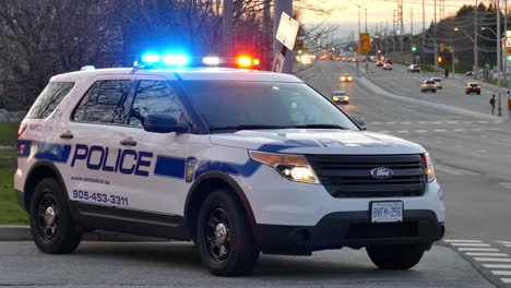 SUV-police-cruiser-parked-on-side-of-road-with-emergency-beacon-lights-blinking