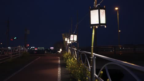 Lanterns-along-river-at-night-drifting-in-the-wind,-Omihachiman-Japan