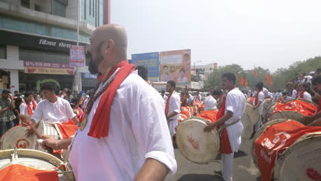An-Indian-in-traditional-attire-playing-huge-drum-known-as-dhol-as-a-part-of-procession-for-celebration