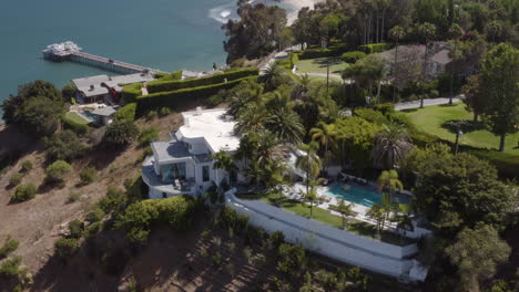 Flying-by-a-mansion-on-a-hillside-in-Malibu-with-Surfrider-beach-and-the-Malibu-pier-in-the-background