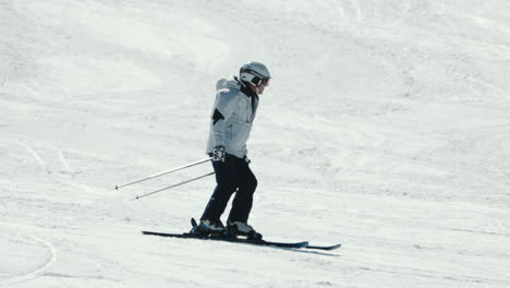 Kamerafahrt-Eines-Asiatischen-Männlichen-Skifahrers-In-Weißer-Jacke,-Der-An-Einem-Kalten-Wintertag-Bergab-Fährt