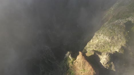 Aerial-shot-of-Pico-das-Torres-in-Madeira-looking-down-on-the-steep-and-dramatic-peaks-and-deep-valleys-during-warm-sunrise