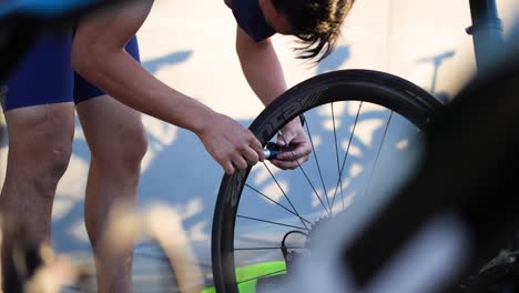 Hombre-Inflando-Neumáticos-De-Bicicleta-En-Competición-De-Triatlón