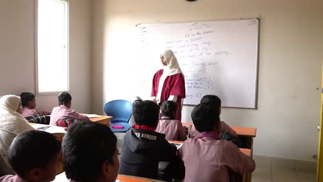 Young-Muslim-School-Children-Listening-To-Their-Teacher-In-Classroom-In-Karachi,-Pakistan