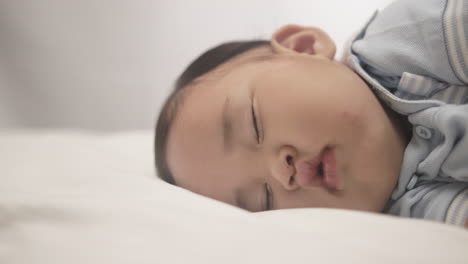 Close-up-Of-Baby-Boy-Lying-And-Sleeping-Comfortably-In-The-Bed