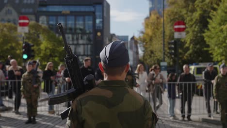 Rücken-Eines-Männlichen-Soldaten-Mit-Waffe,-Der-Während-Der-Militärparade-Auf-Karl-Johan,-Oslo,-Steht