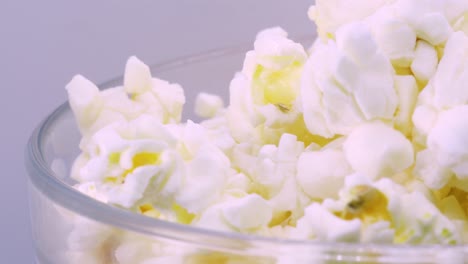 Goldenes-Und-Fettiges-Popcorn-In-Einer-Transparenten-Glasschüssel,-Rotierend