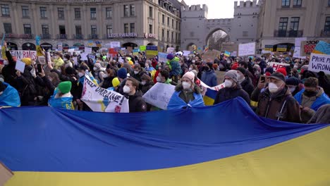 People-hold-Ukrainian-flag-at-peace-demonstration-in-Munich-after-Russia-invades-Ukraine