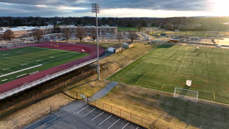 Aerial-of-school-college-university-campus-above-football-soccer-field-in-USA