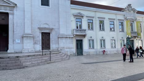 People-walking-outside-São-Roque-museum,-Trindade-Coelho-Square-,-Lisbon