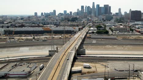 Aerial-Famous-1st-street-bridge,-Los-Angeles-skyline-and-skyscrapers-of-downtown,-urban-scene