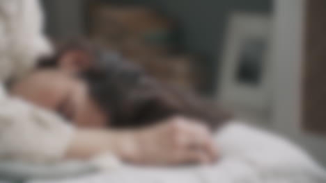 Blurred-portrait-view-of-a-woman-with-eyes-closed-layed-in-bed
